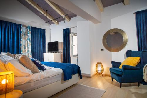 a bedroom with a bed and a chair and a mirror at Villa Iwy in Rovinj