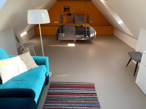 a living room with a blue couch and a bed at Fox in HoÅ¡Å¥ka