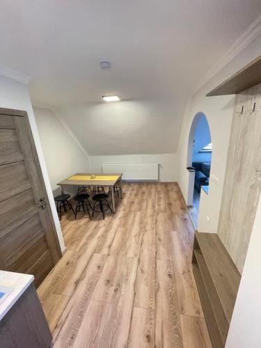 an empty room with a table and a wooden floor at Kukorica Csárda Apartman in Balatonújlak