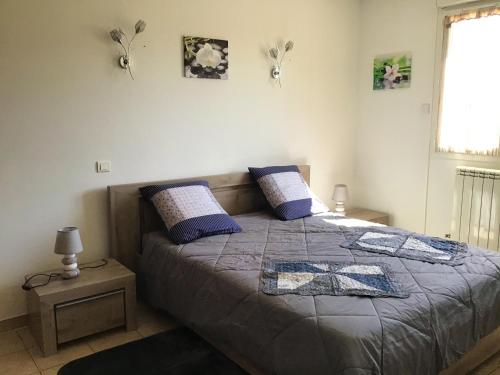 - une chambre avec un lit doté d'oreillers violets et d'une fenêtre dans l'établissement Villa spacieuse avec piscine à Saint-Laurent-la-Vernède, à Saint-Laurent-la-Vernède