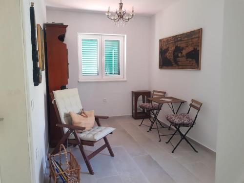 a room with chairs and a table and a window at Family Apartment Miluna in Metajna