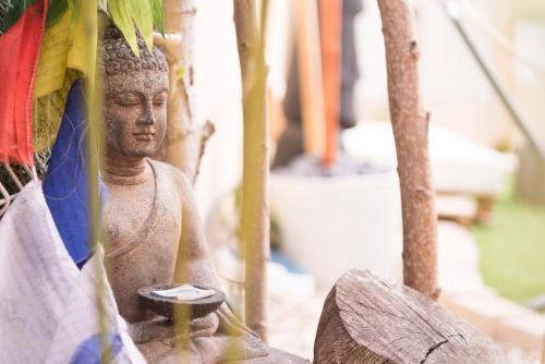 a statue of a buddha sitting next to a building at Finca Olivar de Castilla - Sun&Colors in Segovia