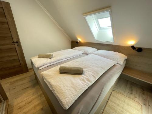 a bedroom with two beds with white sheets and a window at Kukorica Csárda Apartman in Balatonújlak