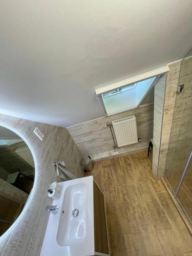 a bathroom with a white sink and a mirror at Kukorica Csárda Apartman in Balatonújlak
