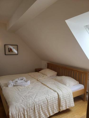 uma cama com lençóis brancos e toalhas em Landhaus Hoisdorf em Hoisdorf