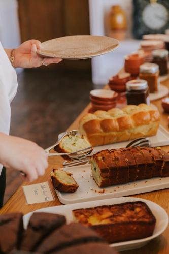 a person holding a plate with food on a table at Oustau Camarguen Hôtel & Spa in Le Grau-du-Roi