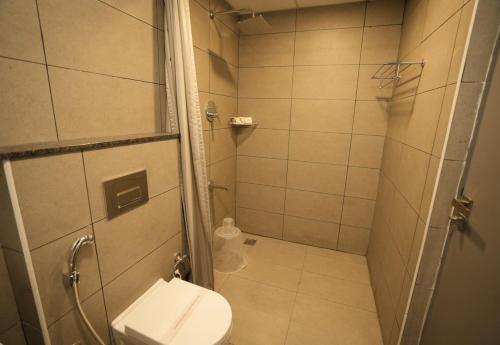 a small bathroom with a toilet and a shower at GRAND GANPAT in Vellore