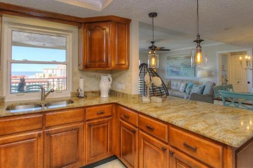 a kitchen with wooden cabinets and a large window at Anglers Cove 608 in St. Pete Beach