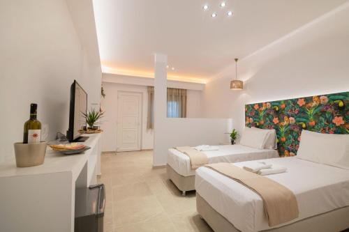 a hotel room with two beds and a couch at Suncourt Lux Rooms in Laganas