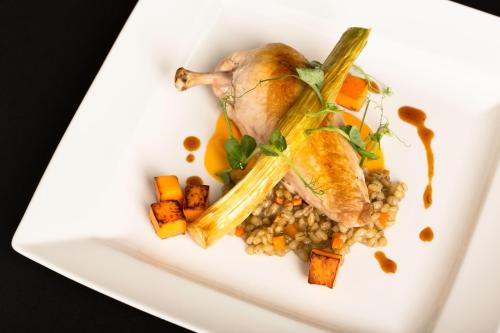 a white plate of food with meat and vegetables at Sandford Springs Hotel and Golf Club in Kingsclere