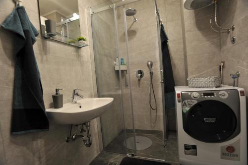 a bathroom with a shower and a sink and a shower at Park Lake - Germa in Tuzla