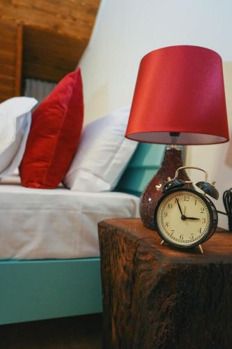 an alarm clock sitting on a table next to a bed at Conacul Sanct Gurgh in Cormaia