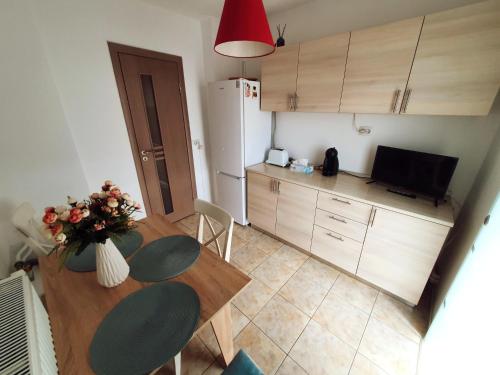 a small kitchen with a table and a refrigerator at SeaLover Apartment in Constanţa