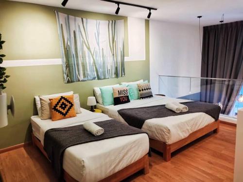 1 dormitorio con 2 camas con almohadas en KL Duplex with balcony@Ekocheras MRT en Kuala Lumpur