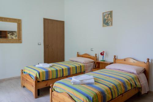 Dos camas una al lado de la otra en una habitación. en Reno Family House, en Rávena
