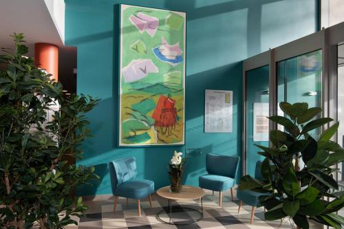 une salle d'attente avec des chaises et un tableau sur le mur dans l'établissement DOMITYS La SARDONNE centre-ville, au Puy-en-Velay