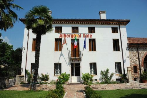 a building with two flags in front of it at Hotel Albergo al Sole in Malo