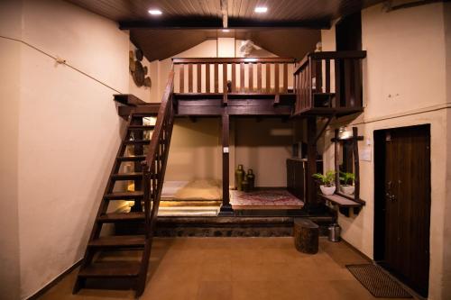 a loft bed in a room with a staircase at Achalaa Resort in Kolhapur