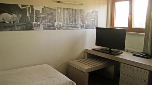 a bedroom with a desk with a computer on it at Tähetorni Hotel in Tallinn