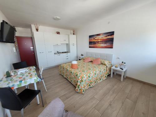 una camera con letto, tavolo e TV di Rosato 3 Sea View Apartment a Lignano Sabbiadoro