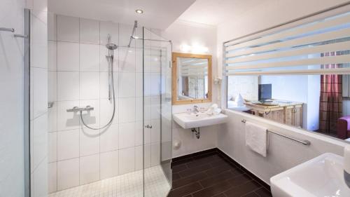 a bathroom with a shower and a sink at Familiengut Hotel Burgstaller in Döbriach