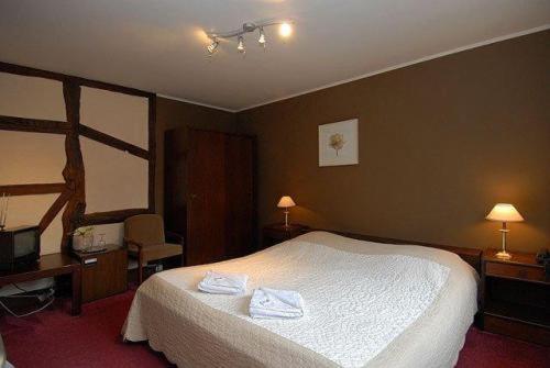 a bedroom with a bed with two towels on it at Hostellerie Au Vieux Hetre in Jalhay