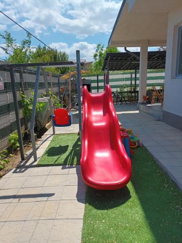 a red slide on a playground in a yard at Casa Inna Venus in Venus