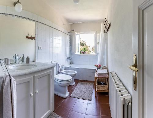 a bathroom with a toilet and a sink and a tub at La Dimora di Corte a Lucca in Lucca