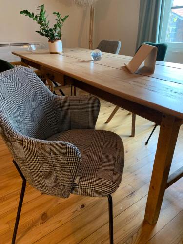 a wooden table with a chair and a laptop on it at La Ferme du Puy d'Or in Limonest