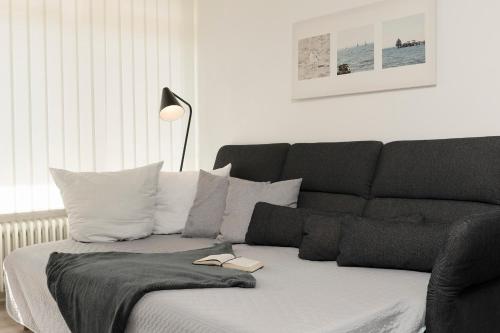 - un canapé noir et blanc dans le salon dans l'établissement Villa am Meer Pier 52, à Grömitz