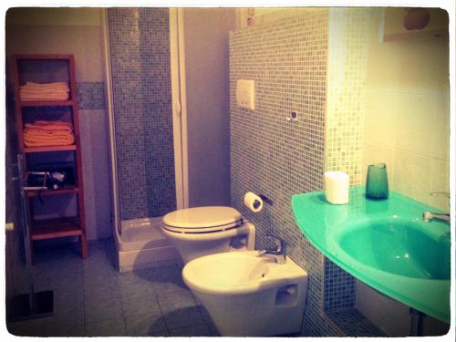 a bathroom with a toilet and a green sink at B&B Borgomarino in Pescara