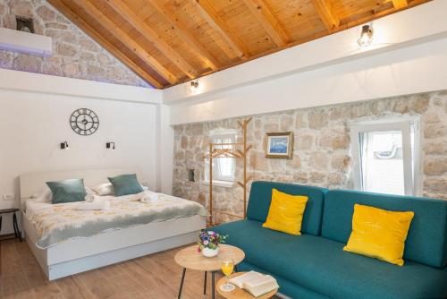 a living room with a couch and a bed at PERLA - small comfy house with the terrace in Prožura