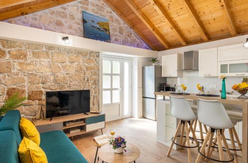 a kitchen and living room with a stone wall at PERLA - small comfy house with the terrace in Prožura