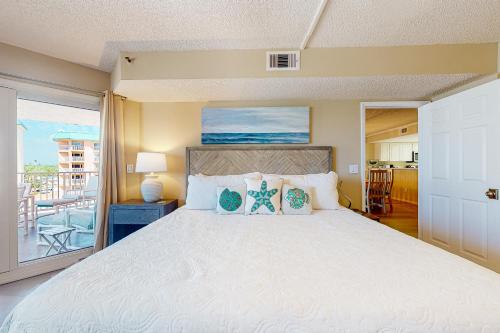 ein Schlafzimmer mit einem großen Bett und einem Balkon in der Unterkunft Beach Cottage 1311 in Clearwater Beach