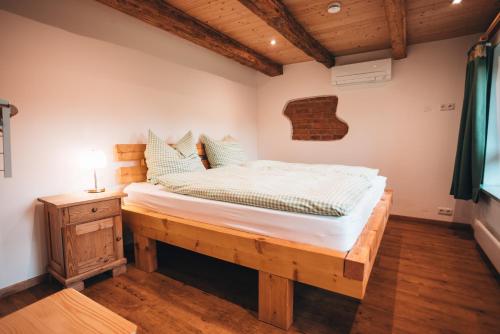 um quarto com uma cama e uma mesa de cabeceira com um candeeiro em Ferienhaus Woidhaus em Kollnburg