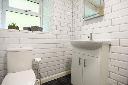 ein weißes Badezimmer mit Toilette und Waschbecken in der Unterkunft Lyn View Cottage - Modern Lynmouth Townhouse in Lynmouth