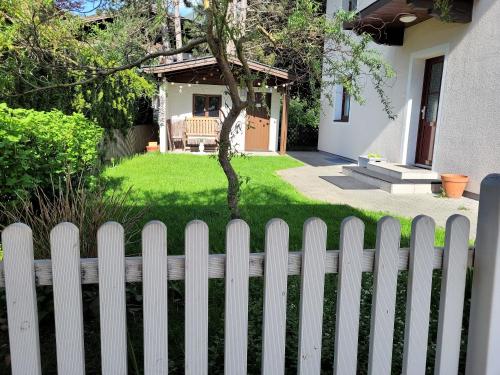 una cerca blanca delante de un patio en The Steinbock Lodge with garden and bbq, en Zell am See