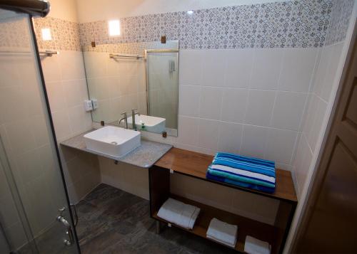 La salle de bains est pourvue d'un lavabo et d'un miroir. dans l'établissement Leuchtturm Resort, à Boljoon