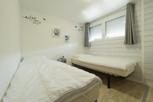 2 lits dans une chambre d'hôpital avec fenêtre dans l'établissement Chalet pour 6 au coeur de St Hilaire de Riez, à La Parée Preneau