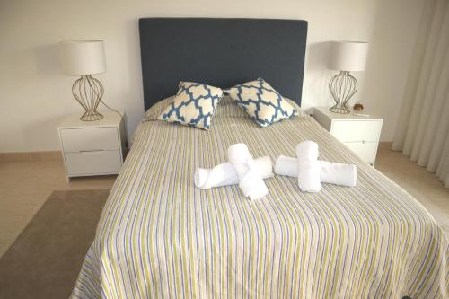 Una cama con dos toallas encima. en Apartamento Deolinda - Nossa Sra da Rocha, en Porches