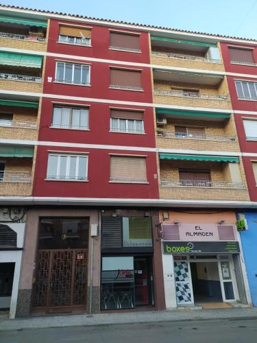 - un bâtiment rouge avec des boutiques en face dans l'établissement El Refugio, à Calatayud