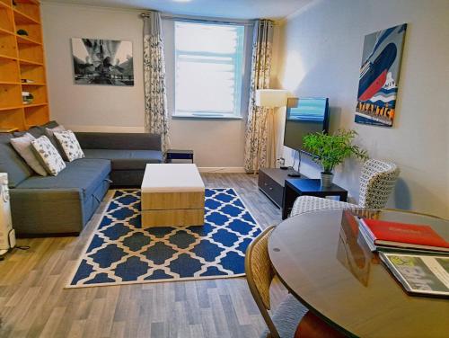 ein Wohnzimmer mit einem Sofa und einem Tisch in der Unterkunft Excellent Location -Central Belfast - Parking - 4 Beds in Belfast