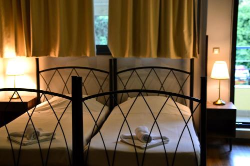 a bedroom with a black bed with two lamps at RentRooms Thessaloniki in Thessaloniki