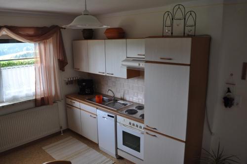 a kitchen with white cabinets and a white refrigerator at Ferienwohnung Höbart in Dorfstetten