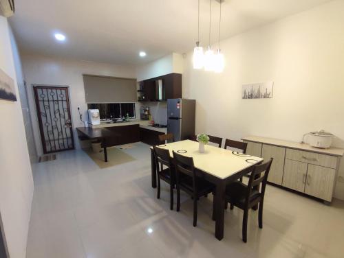 a kitchen and dining room with a table and chairs at Triple Z Homestay Kuching - LANDED 14 PAX in Kuching