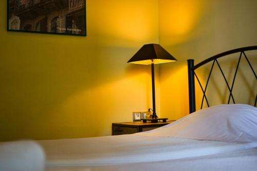 a bedroom with a bed with a lamp on a table at RentRooms Thessaloniki in Thessaloniki
