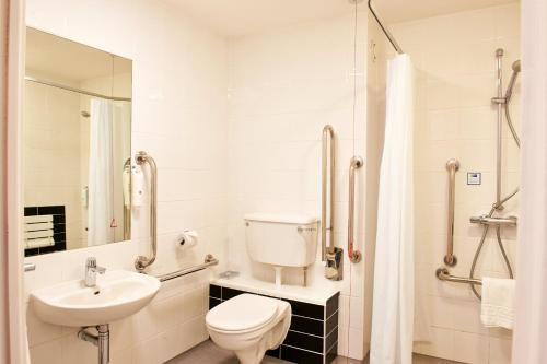 a white bathroom with a toilet and a sink at Holiday Inn Express Manchester Airport by IHG in Hale