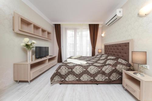 een slaapkamer met een bed en een tv. bij Harmony Suites - Dream Island in Sunny Beach