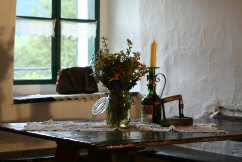 a vase of flowers on a table with a candle at Ferienhaus Eckstoa in Abtenau