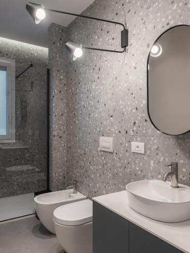 a bathroom with a sink and a toilet and a mirror at Living u HomeSuites in Lecce